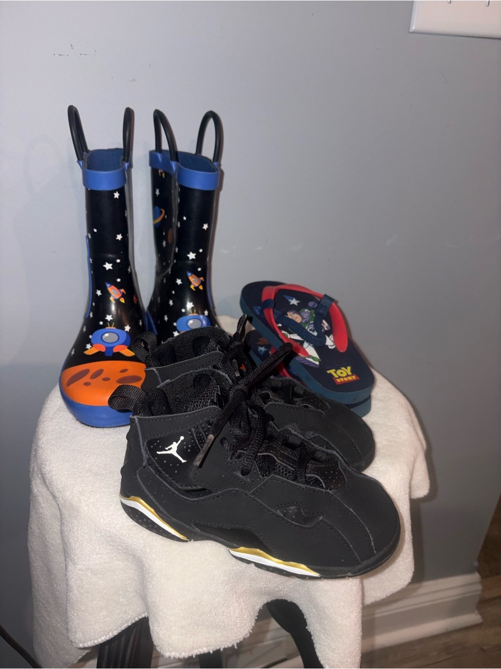 Black Jordan Kids Sneakers with Toy Story Flip Flops and Space Rain Boots